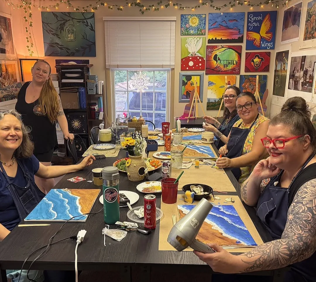 A group painting ocean canvases with drinks at a Paint & Sip night at InDreams Art Experience in Medford, NJ